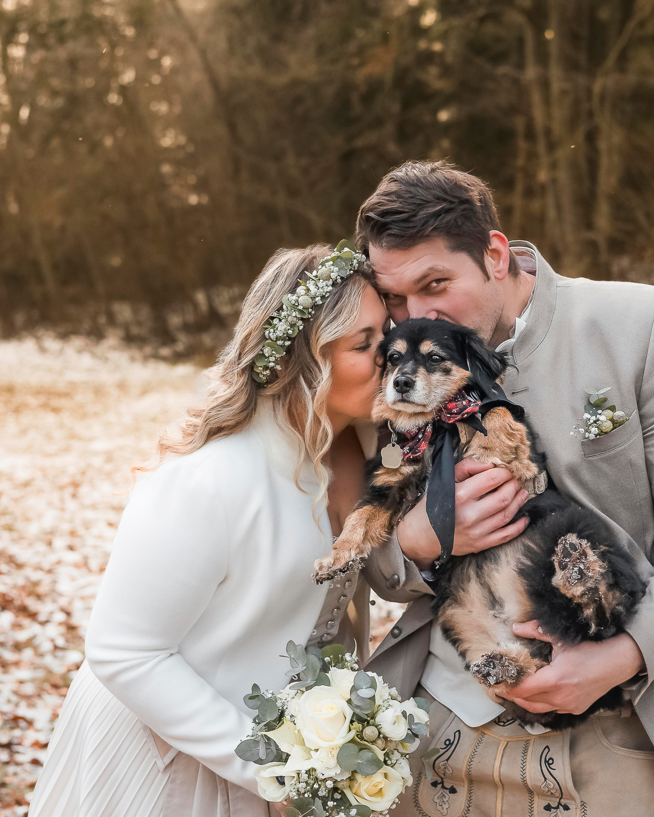 Hochzeitsfotografin Augsburg – Brautpaar küsst Hund Winterhochzeit natürliche Hochzeitsfotos